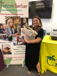 Librarian holding a kangaroo at a summer reading program