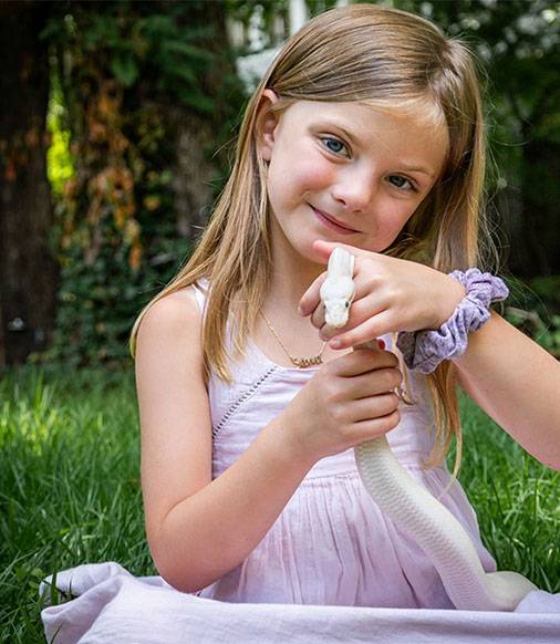 Girl smiling while holding a white python