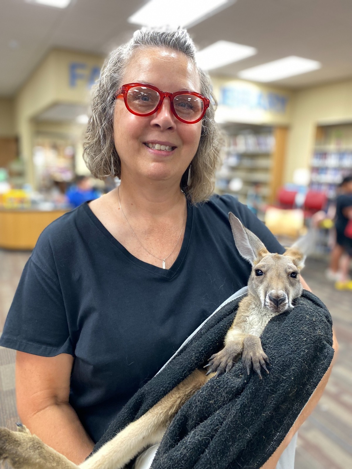 Library Summer Reading program with librarian holding a baby kangaroo