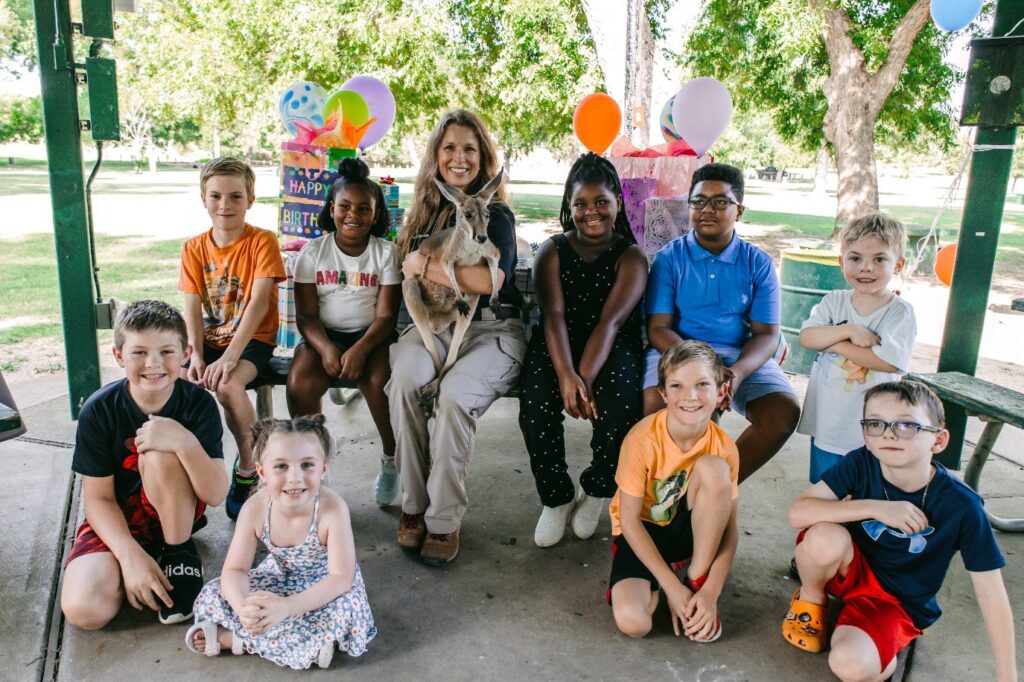 Live animal birthday party with smiling children and a kangaroo