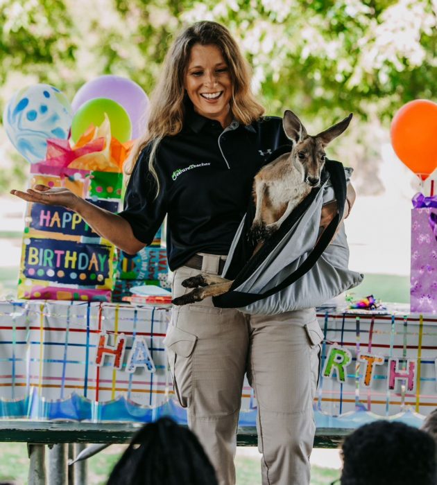 The Creature teacher holding a kangaroo at a live animal birthday party